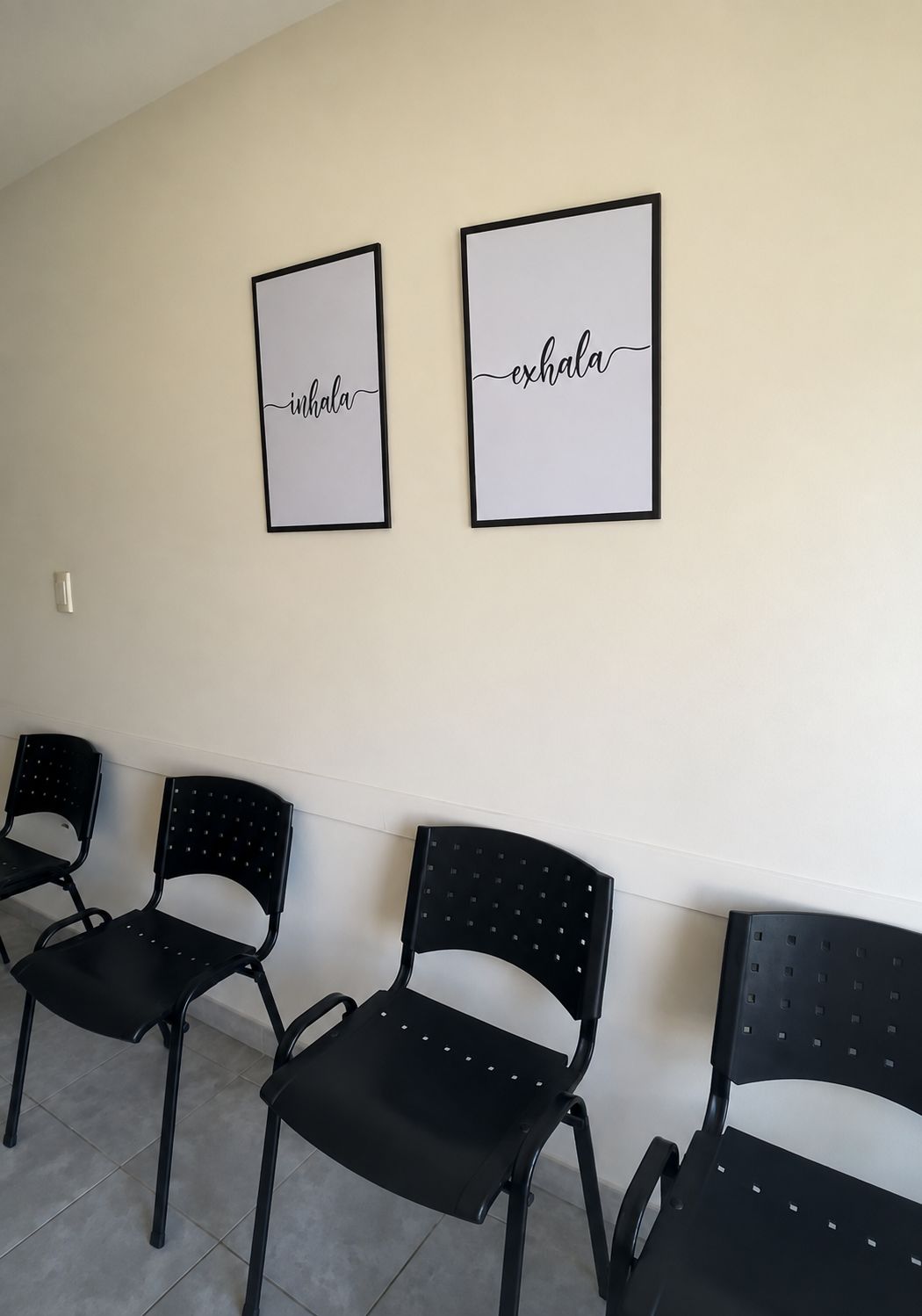 Sala de espera del consultorio de Azul: sillas contra la pared y dos cuadros que dicen "inhala" y "exhala"